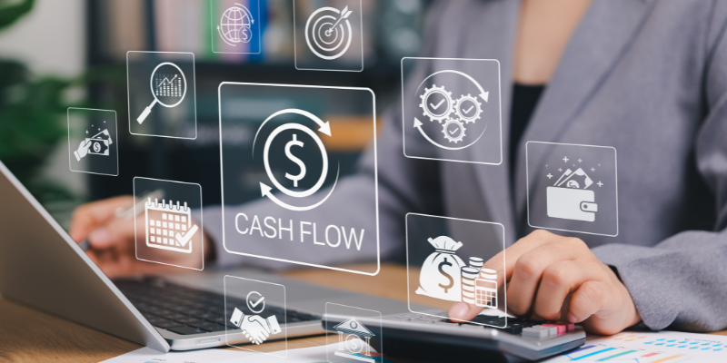 Digital overlay of cash flow metrics, financial planning icons, and business valuation analytics over a laptop worker.