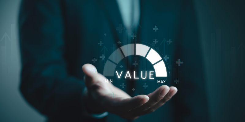 Professional holding an open hand beneath a digital value gauge meter pointing toward maximum valuation